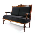 A 19th century Continental mahogany and upholstered two seater settee surmounted with a foliate
