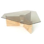 An Indian coffee table, the smoked glass surface resting on three soapstone supports,