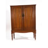 An Edwardian century oak cabinet, the two panelled doors enclosing a fitted interior,