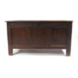 An 18th century oak coffer, the three front panels with carved framework on square straight stiles,