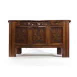 An 18th century and later oak coffer, the front with three carved panels on square straight stiles,