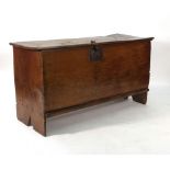 A 17th century oak six plank coffer, the hinged lid enclosing a candle box, on shaped side supports,