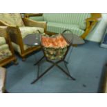 An early 20th century mahogany and fabric concertina sewing basket with metal support rods