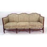 An early 20th century beech and upholstered Queen Anne-type three seater sofa on cabriole feet