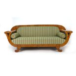 An Empire-type birch and upholstered three seater sofa on scrolled feet with two fitted cushions