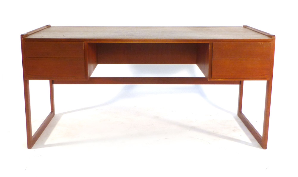 A 1970's teak desk with an arrangement on four drawer with a gallery section to the rear on square