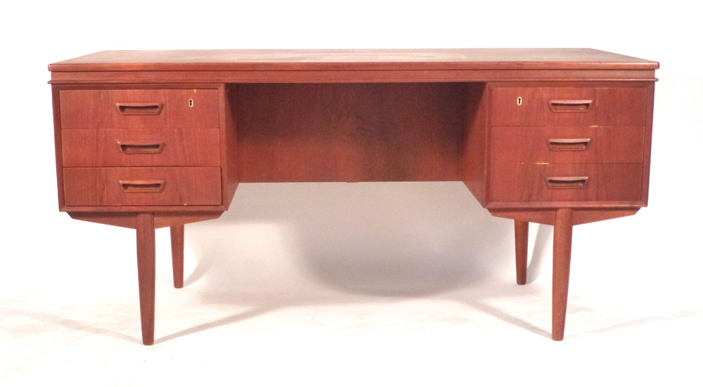 A 1970's teak desk with an arrangement of six drawers and a gallery section to the rear on teak