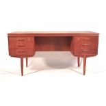 A 1970's teak desk with an arrangement of six drawers and a gallery section to the rear on teak