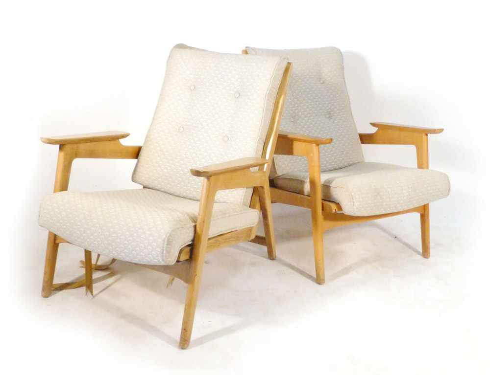 A pair of 1950's beech framed lounge armchairs with loose upholstery on tapering legs,