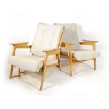 A pair of 1950's beech framed lounge armchairs with loose upholstery on tapering legs,