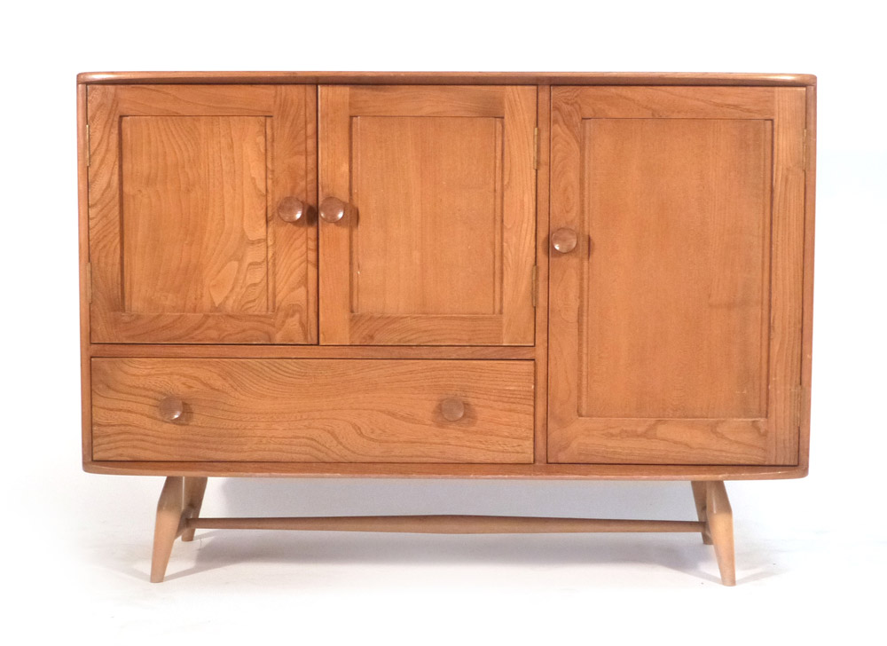 An Ercol elm and beech sideboard with an arrangement of three doors one drawers on tapering legs. w.