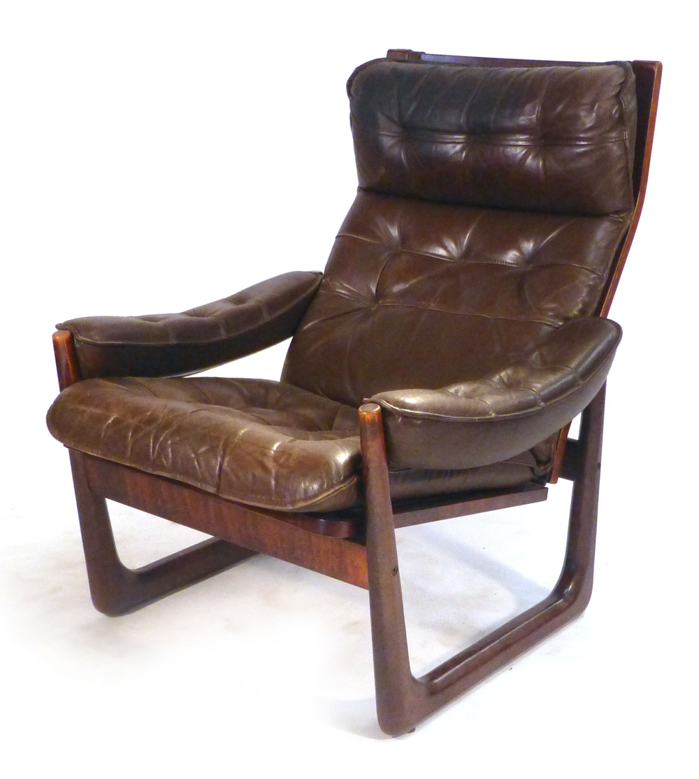 A 1970's stained beech and brown button upholstered adjustable reclining armchair on a sleigh-type