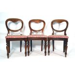 A set of six Victorian mahogany and upholstered balloon back dining chairs on turned front legs