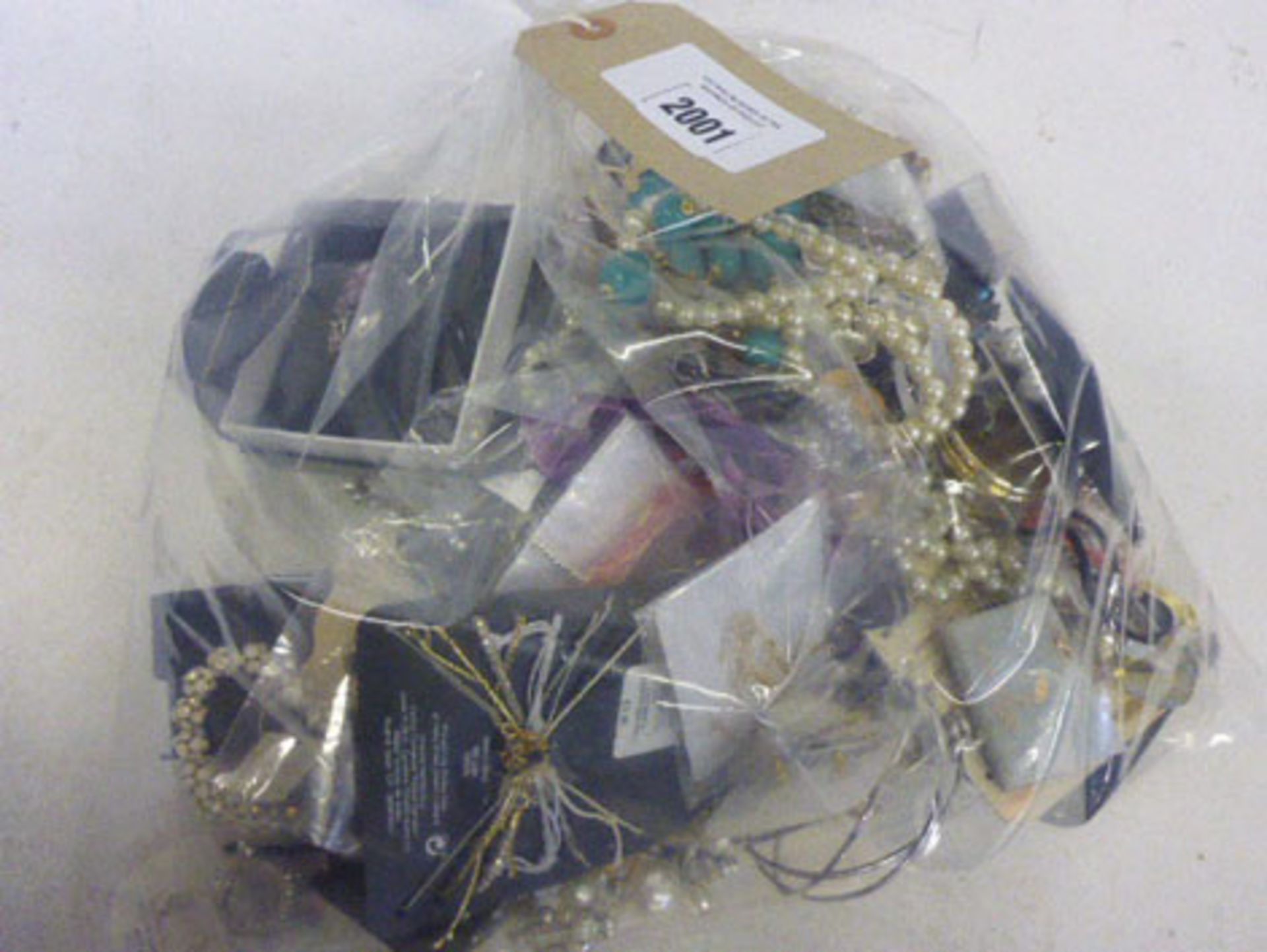 A bag containing mixed costume and dress jewellery
