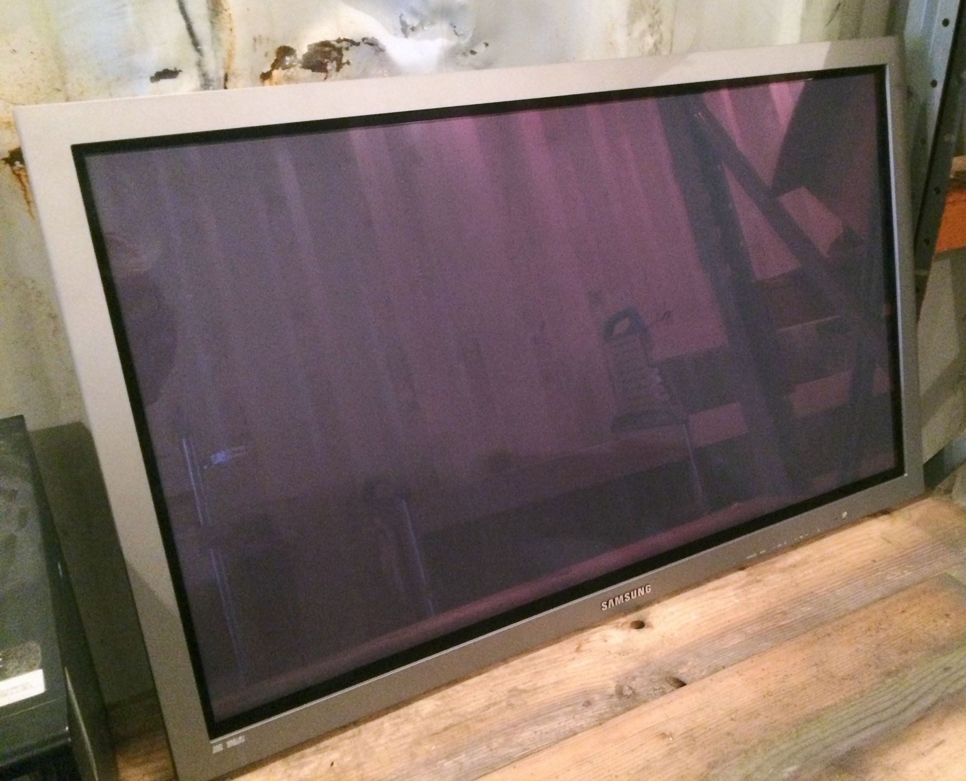 A Samsung PPM42M71K 42in Plasma Display Screen with remote controller.