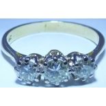 A diamond three-stone ring. The graduated brilliant-cut diamond line, to the tapered
shoulders and