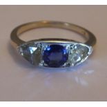 A sapphire and diamond three-stone ring. Size L - The circular-shape sapphire, with triangular-shape