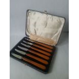 A set of unusual long orange handled cheese knives in original case complete with original inividual