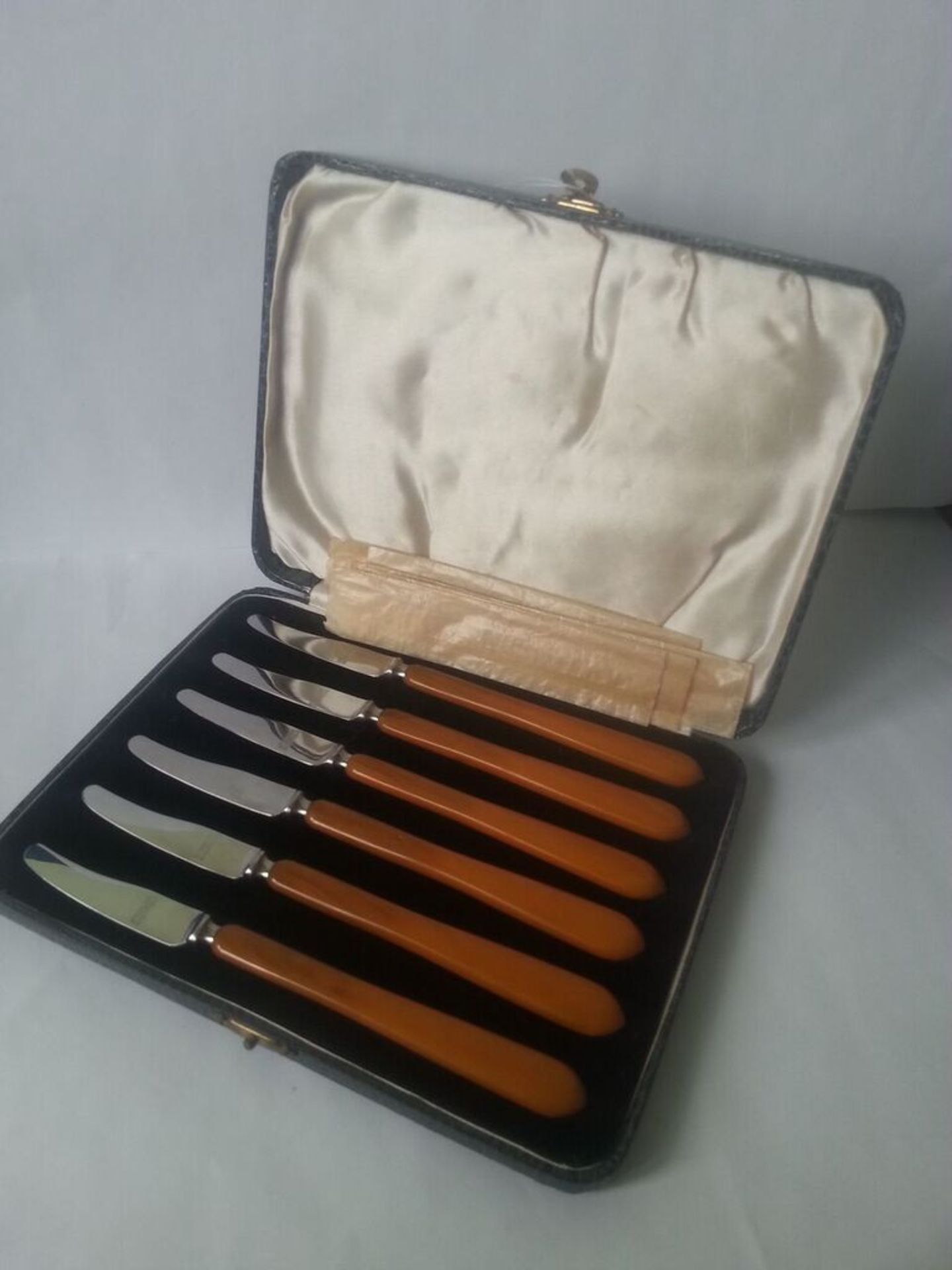 A set of unusual long orange handled cheese knives in original case complete with original inividual