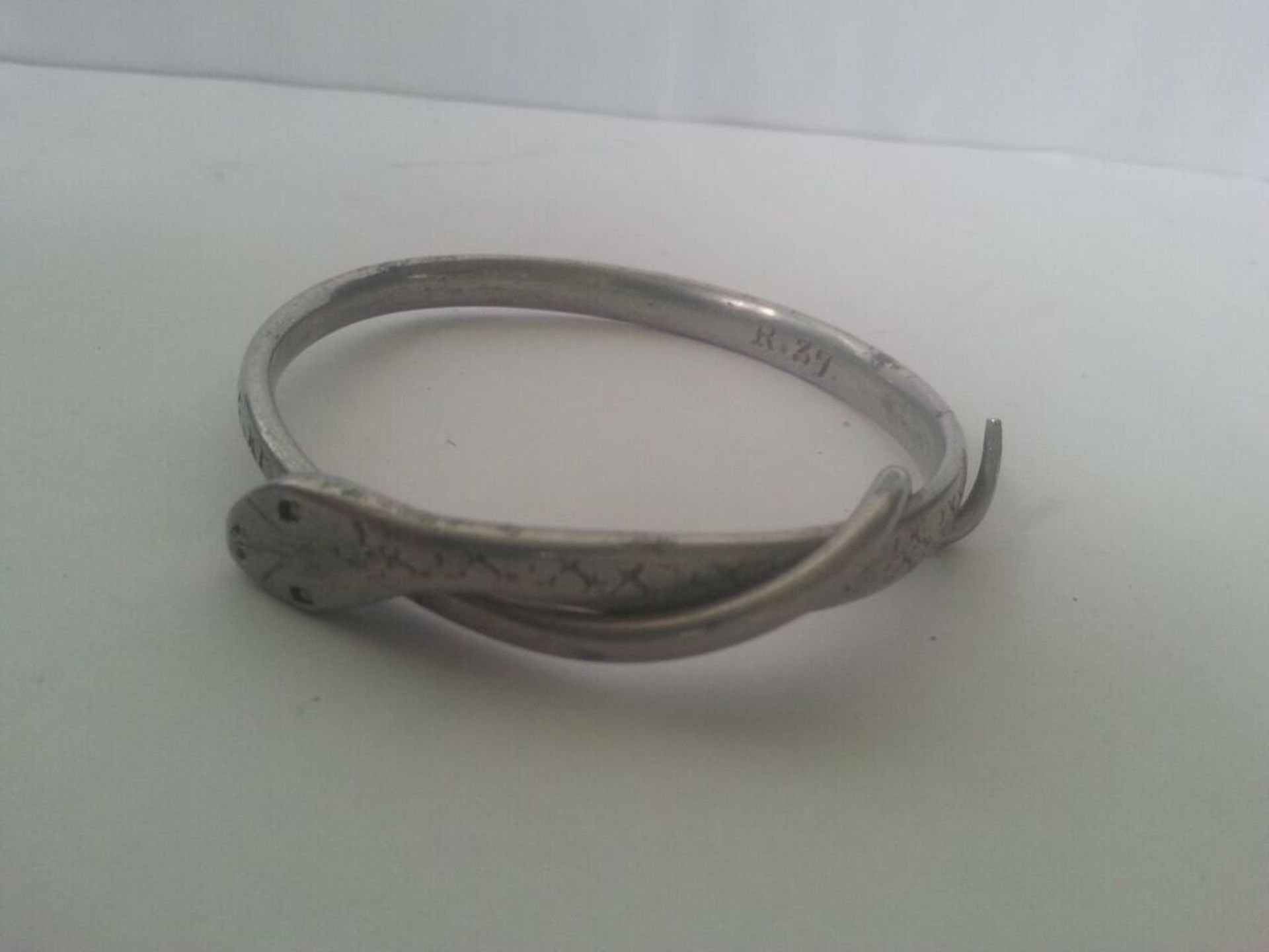 White metal bangle in the form of a snake. Marked "R 37"