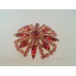 Glamorous brooch set with red and pink stones, approx 4cm in diameter Low cost delivery available on