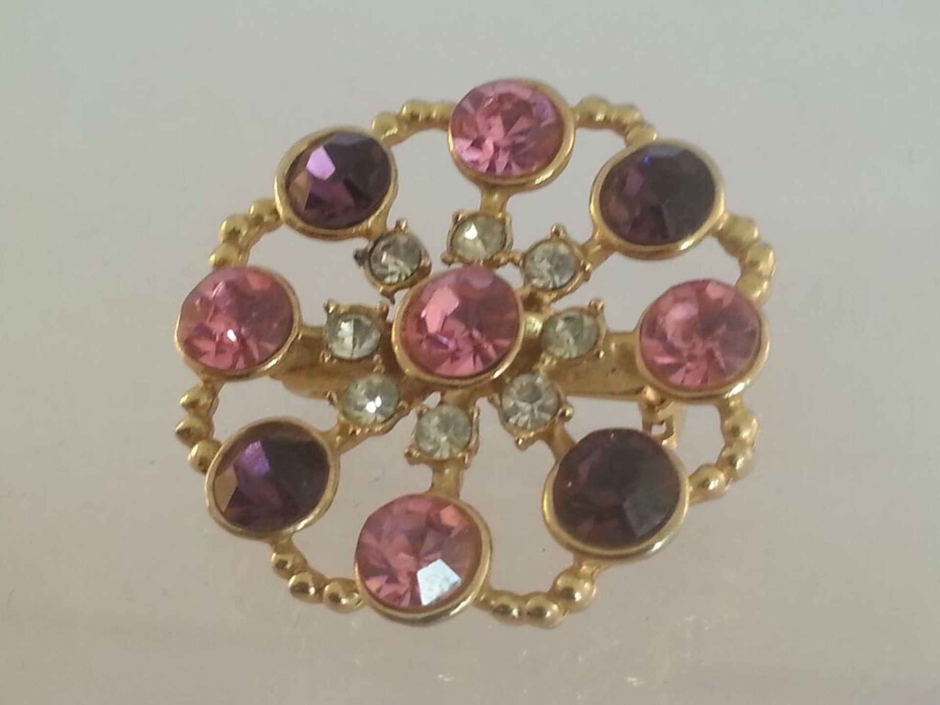 Vintage crystal brooch, approx 3.5cm at widest point. Set with beautiful pink, purple & white