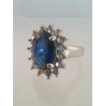 Stunning boxed costume cocktail ring with large central oval cut blue stone surrounded by 15 round
