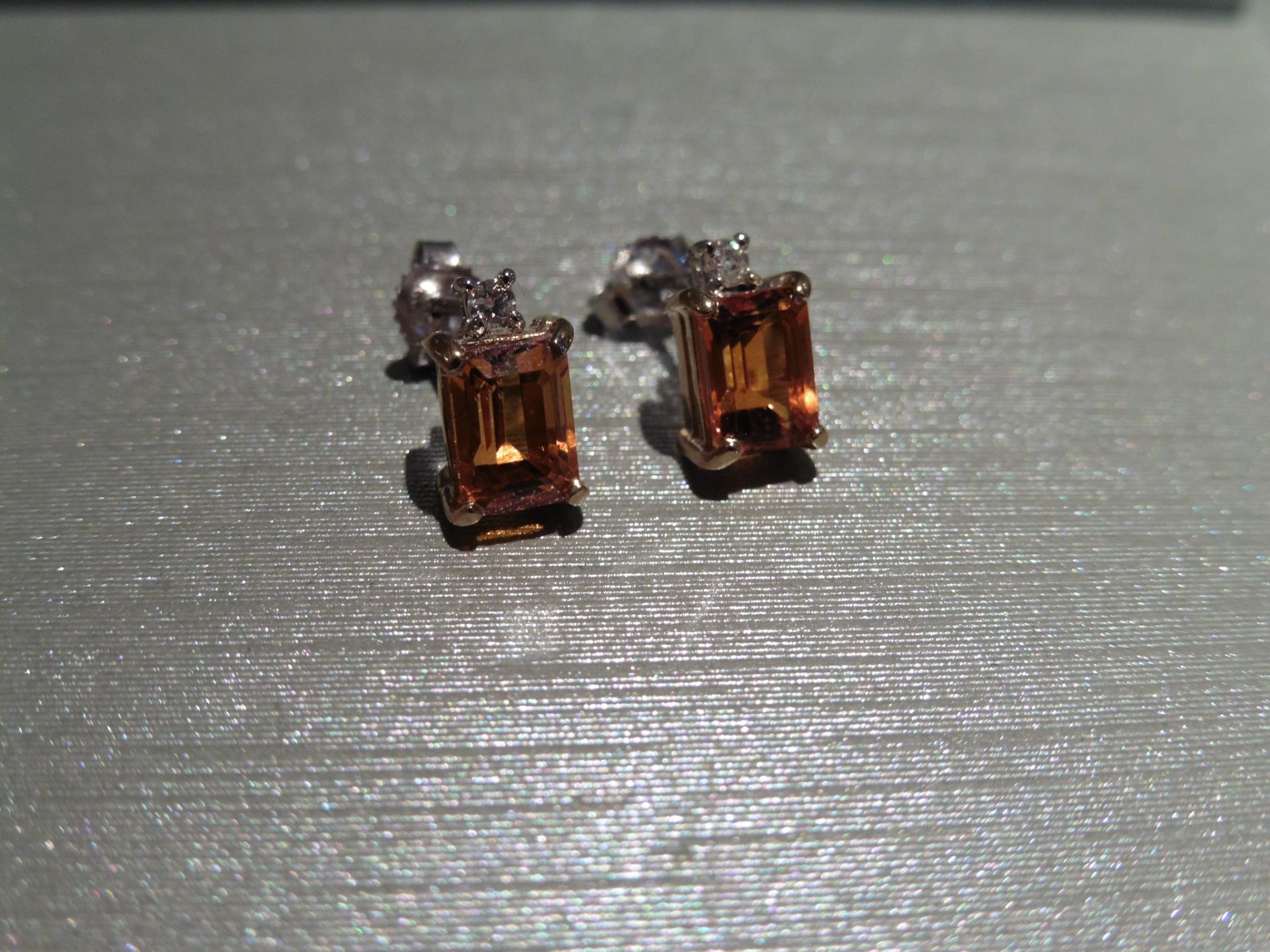 Brand new 9ct gold citrine and diamond earrings. Each set with an emerald cut citrine weighing 1.