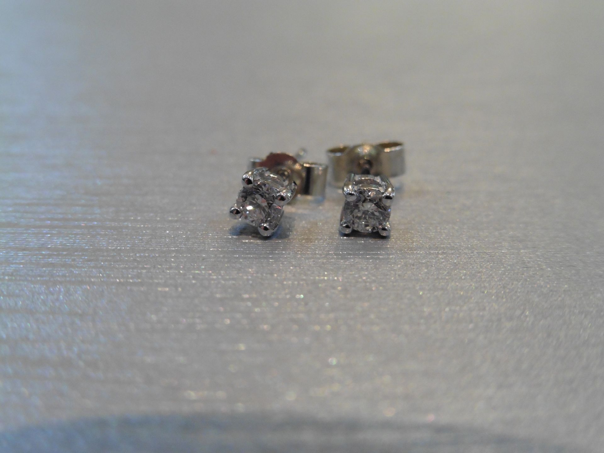 Brand new 9ct white gold solitaire stud earrings each set with a brilliant cut diamond weighing a