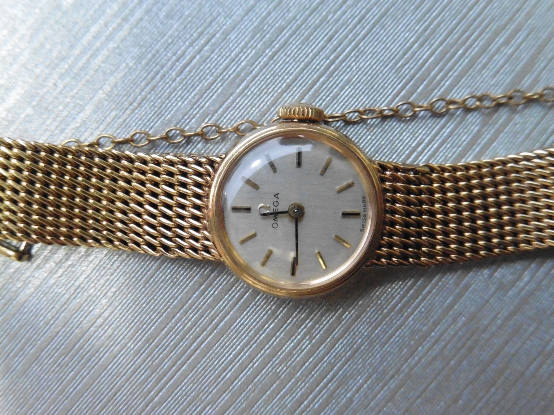 Pre-owned ladies 9ct yellow gold omega watch. Small round face with champagne coloured dial,