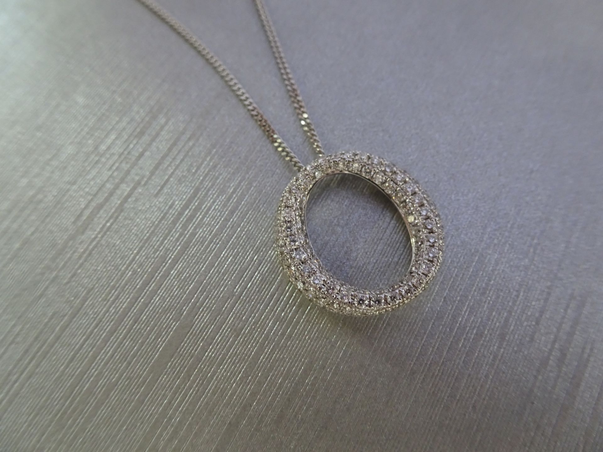 18ct white gold diamond set pendant in an 'o' design. Set with tiny brilliant cut diamonds