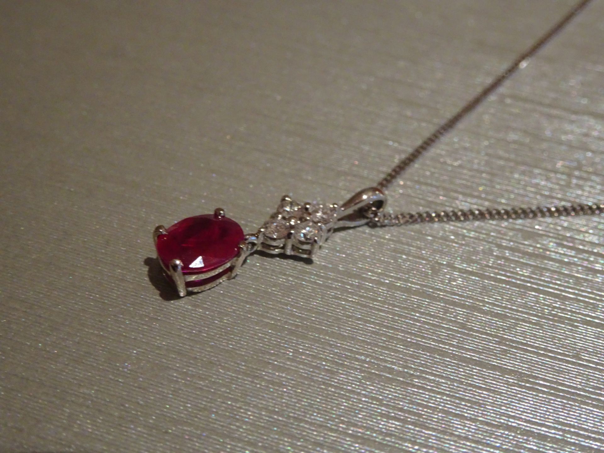 Brand new 18ct white gold ruby and diamond pendant set with an oval cut ruby weighing 1.50ct. Set on - Image 2 of 3
