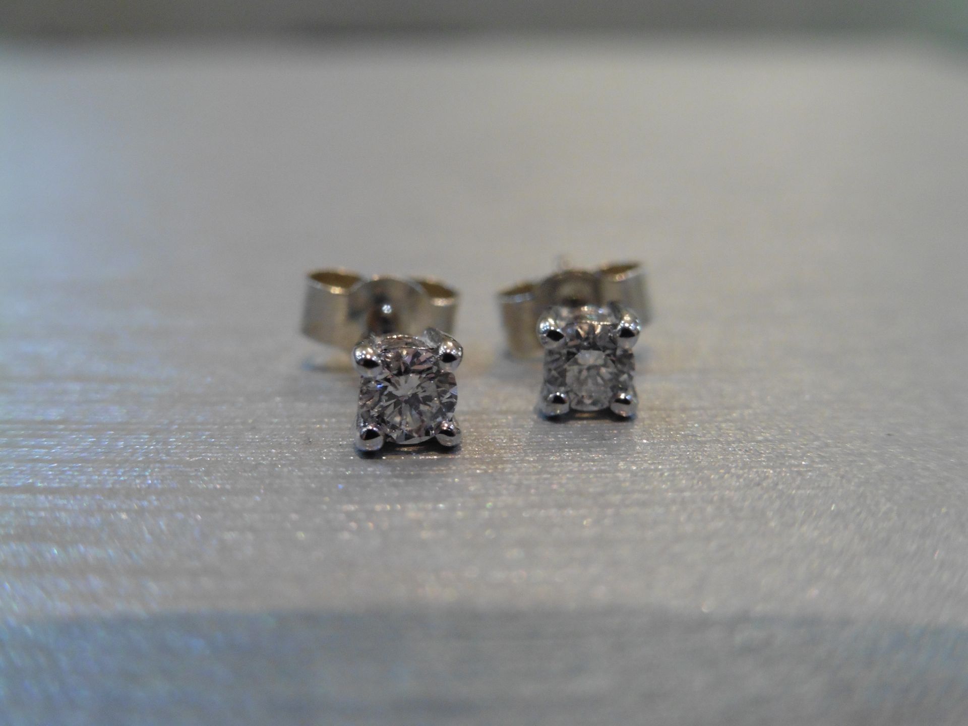 Brand new 9ct white gold solitaire stud earrings each set with a brilliant cut diamond weighing a