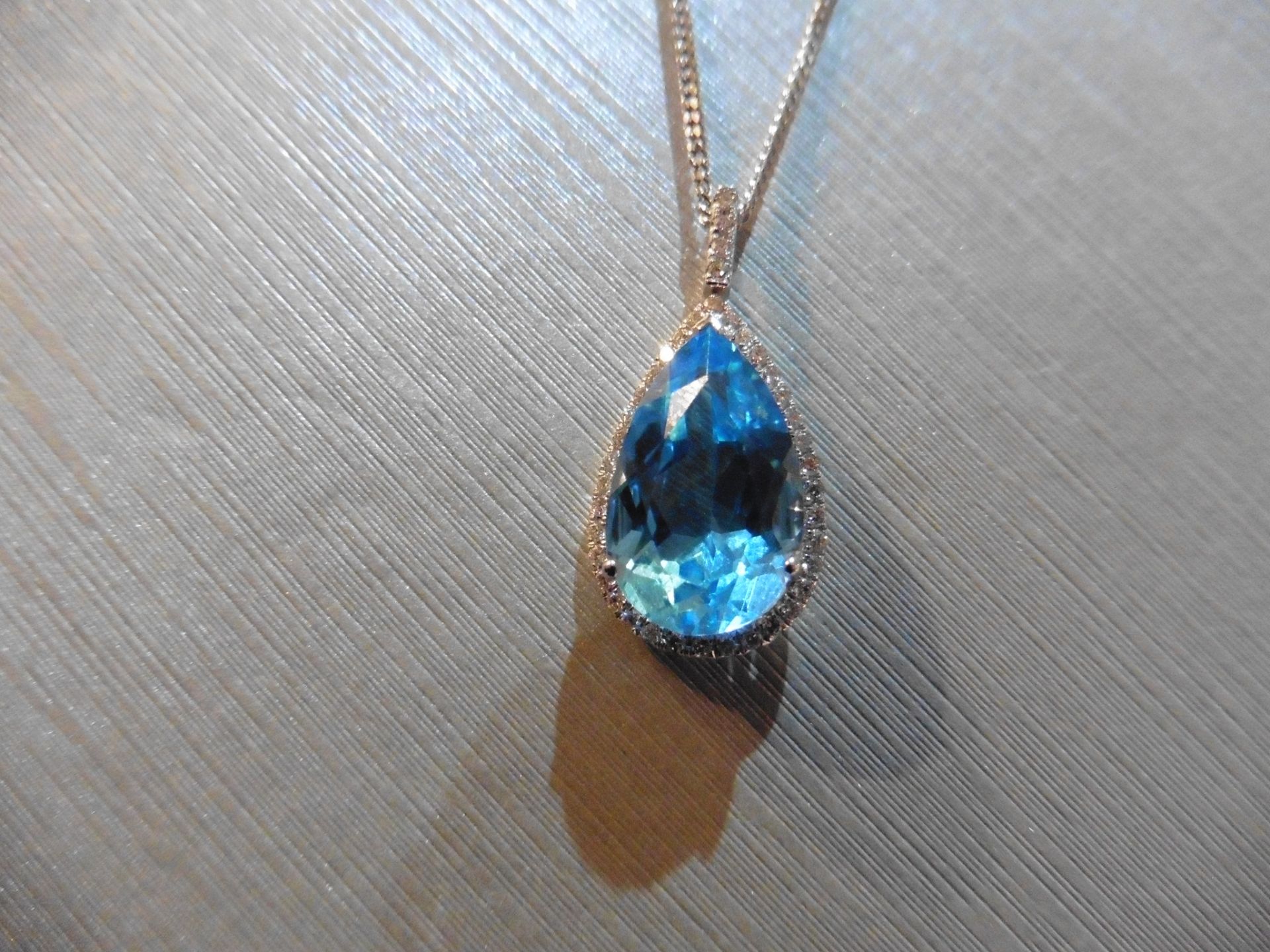 Brand new 9ct white gold blue topaz and diamond pendant. Set with a pear shaped blue topaz