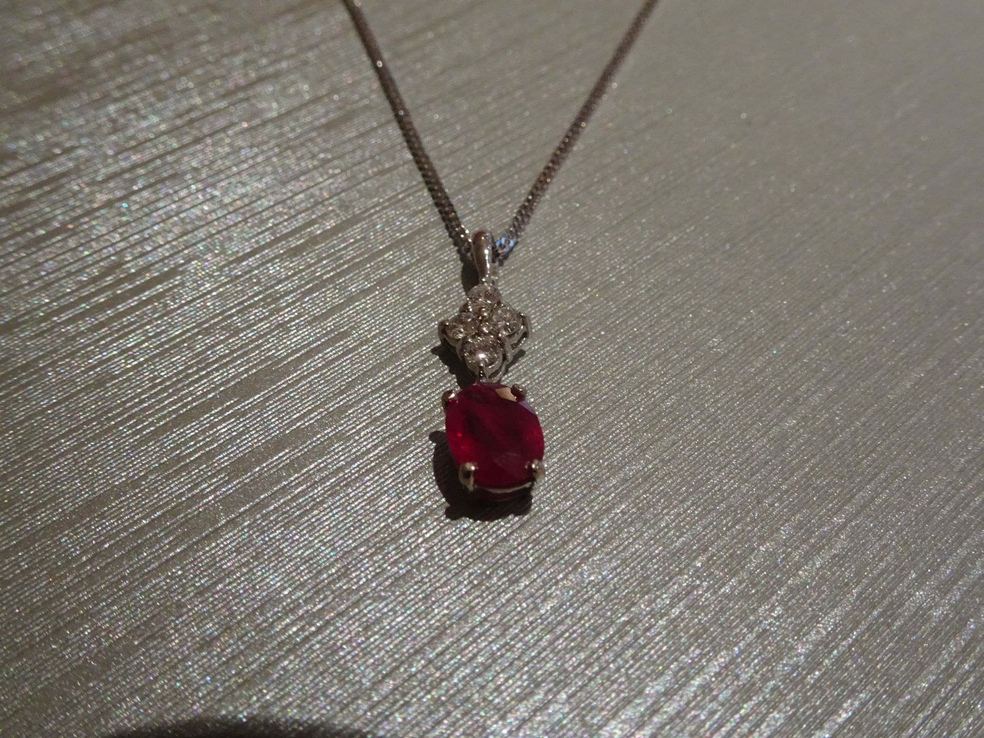 Brand new 18ct white gold ruby and diamond pendant set with an oval cut ruby weighing 1.50ct. Set on