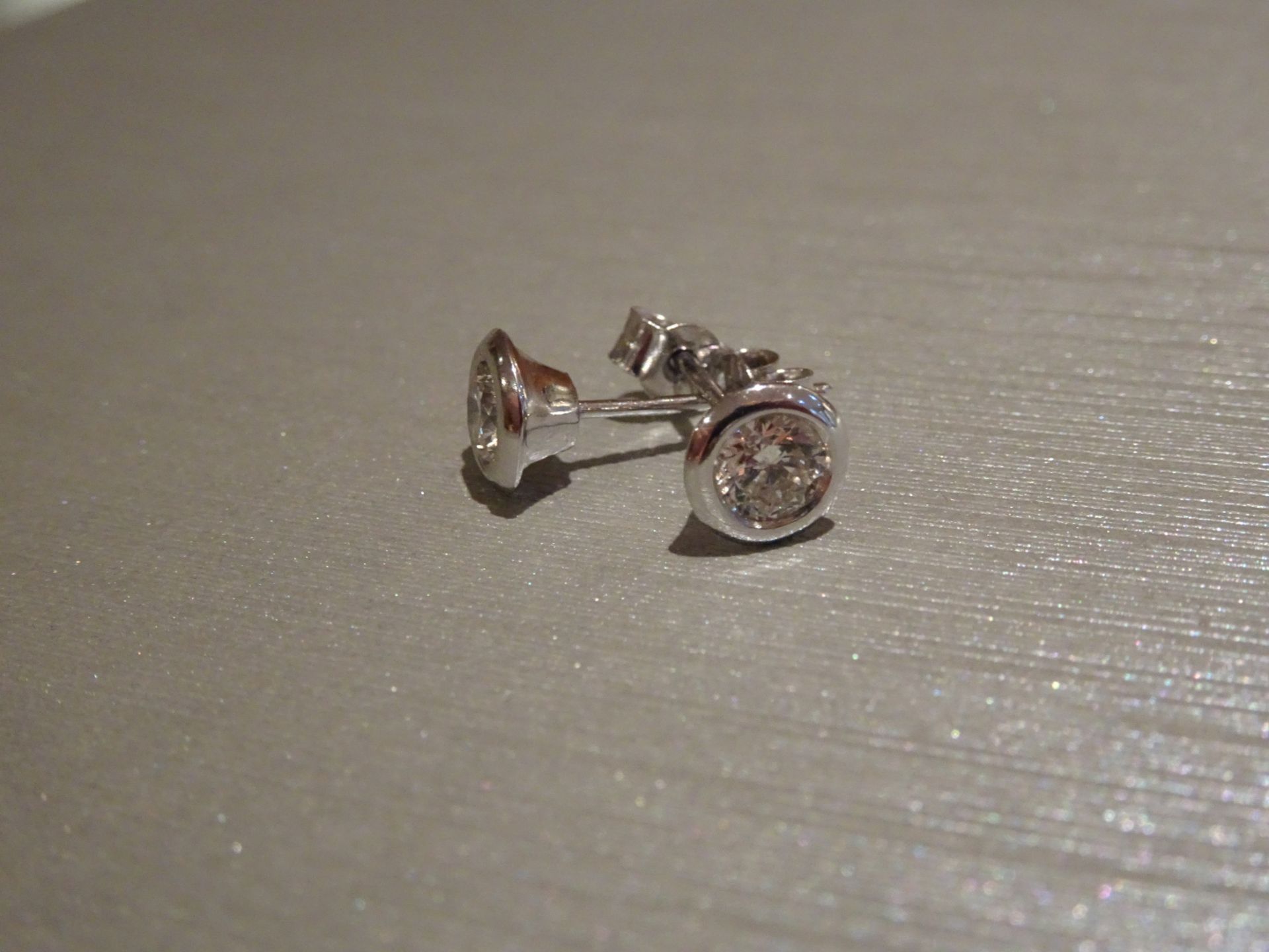 Brand new 18ct white gold diamond solitaire style earrings each set with a brilliant cut diamond,