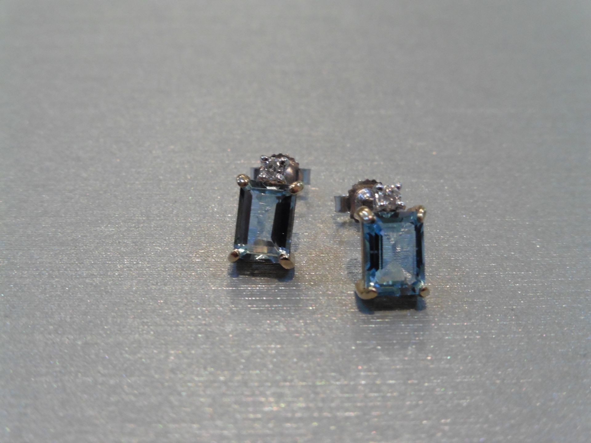 Brand new 9ct gold aqua marine and diamond earrings. Each set with an emerald cut aqua weighing 1.
