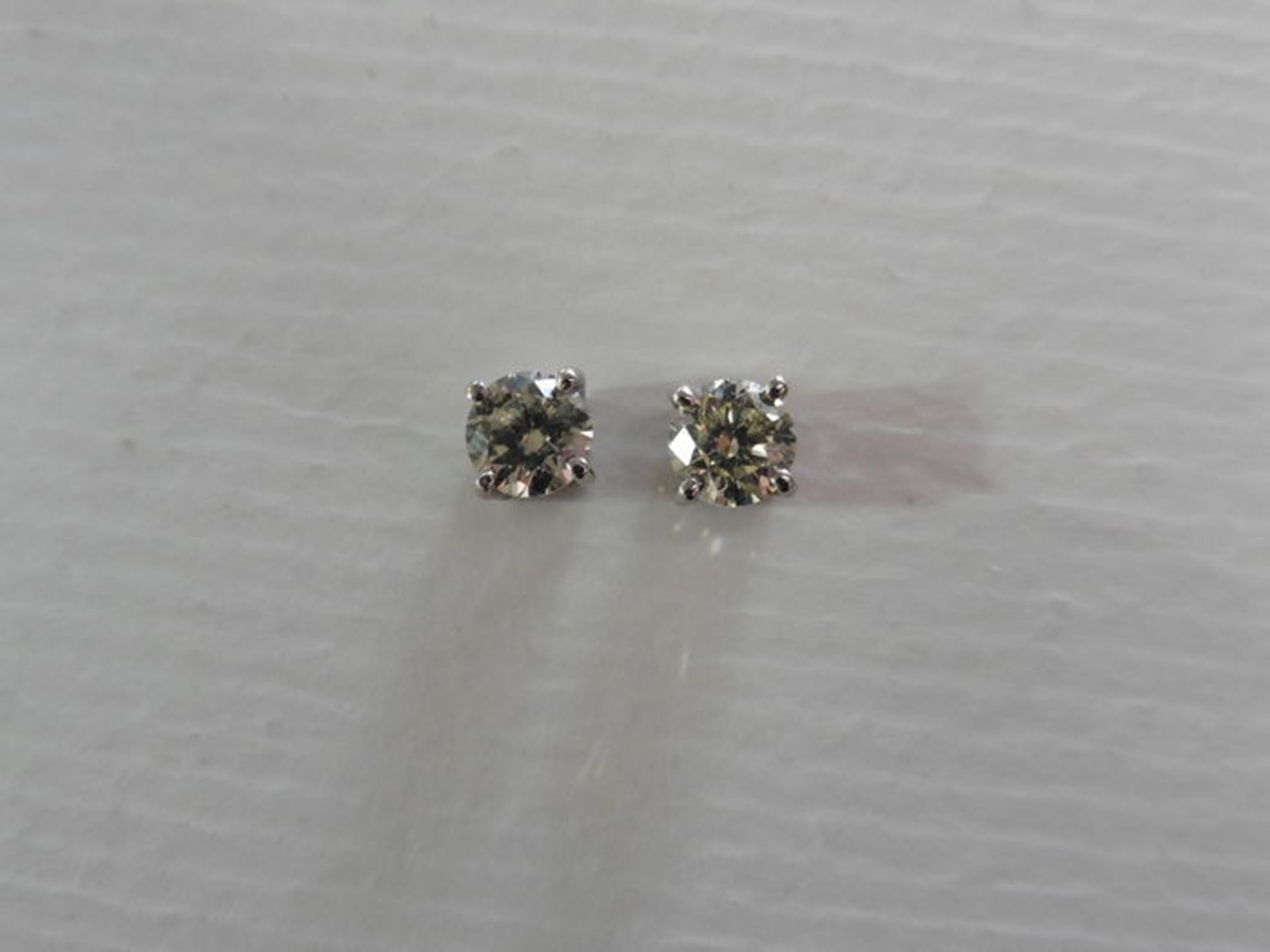 Brand new 18ct white gold solitaire stud earrings each set with a brilliant cut diamond weighing a