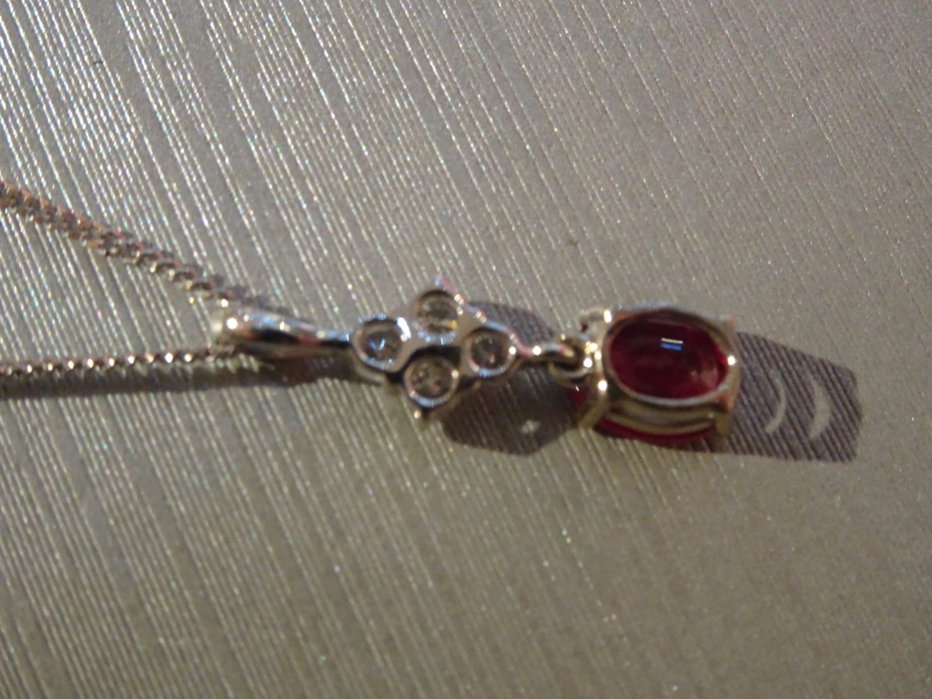 Brand new 18ct white gold ruby and diamond pendant set with an oval cut ruby weighing 1.50ct. Set on - Image 3 of 3