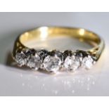 An 18ct gold diamond five-stone ring. Size J. The graduated old cut diamond line, to the tapered
