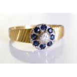 An 18ct gold Diamond and sapphire ring. A single diamond surrounded by sapphires. 2.6 grms - size M