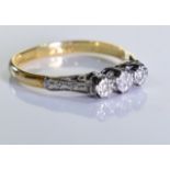 An 18ct Gold and platinum diamond ring. Three brilliant cut diamonds set in an 18ct gold and