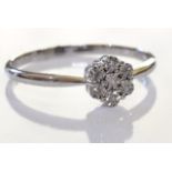 A 9ct gold diamond floral cluster ring. The illusion-set single-cut diamond, within a similarly-