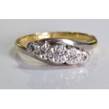 An 18ct gold diamond five-stone ring. Five brilliant-cut diamonds, to the crossover gallery and