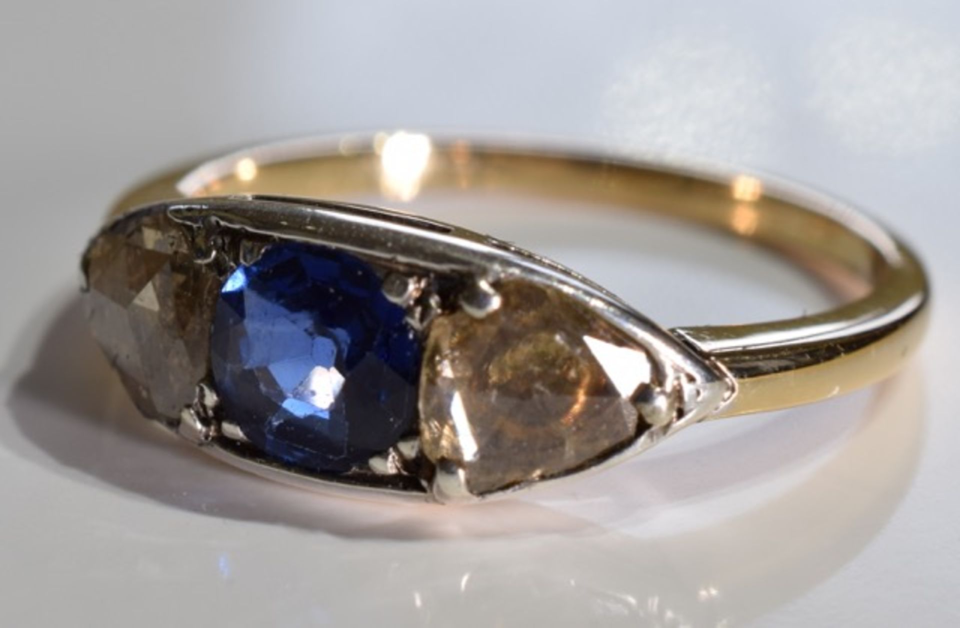 A sapphire and diamond three-stone ring. Size L - The circular-shape sapphire, with triangular-shape - Image 2 of 3