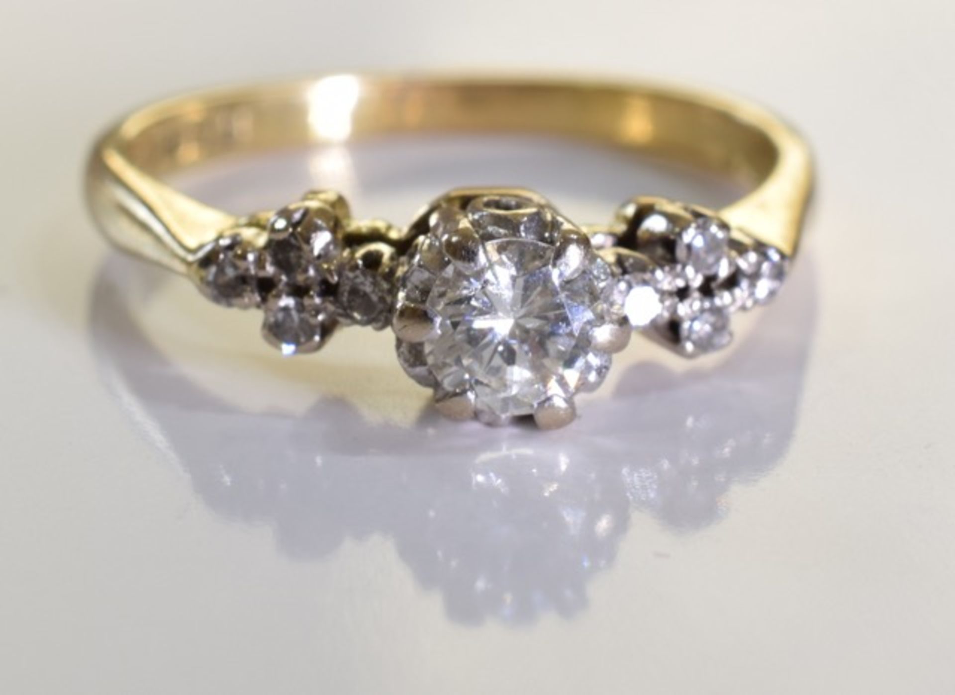 An 18ct gold diamond single-stone ring. The brilliant-cut diamond, raised to the single-cut