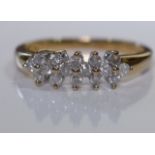 A 9ct gold diamond dress ring. Designed as a series of shared brilliant-cut diamond quatrefoils,