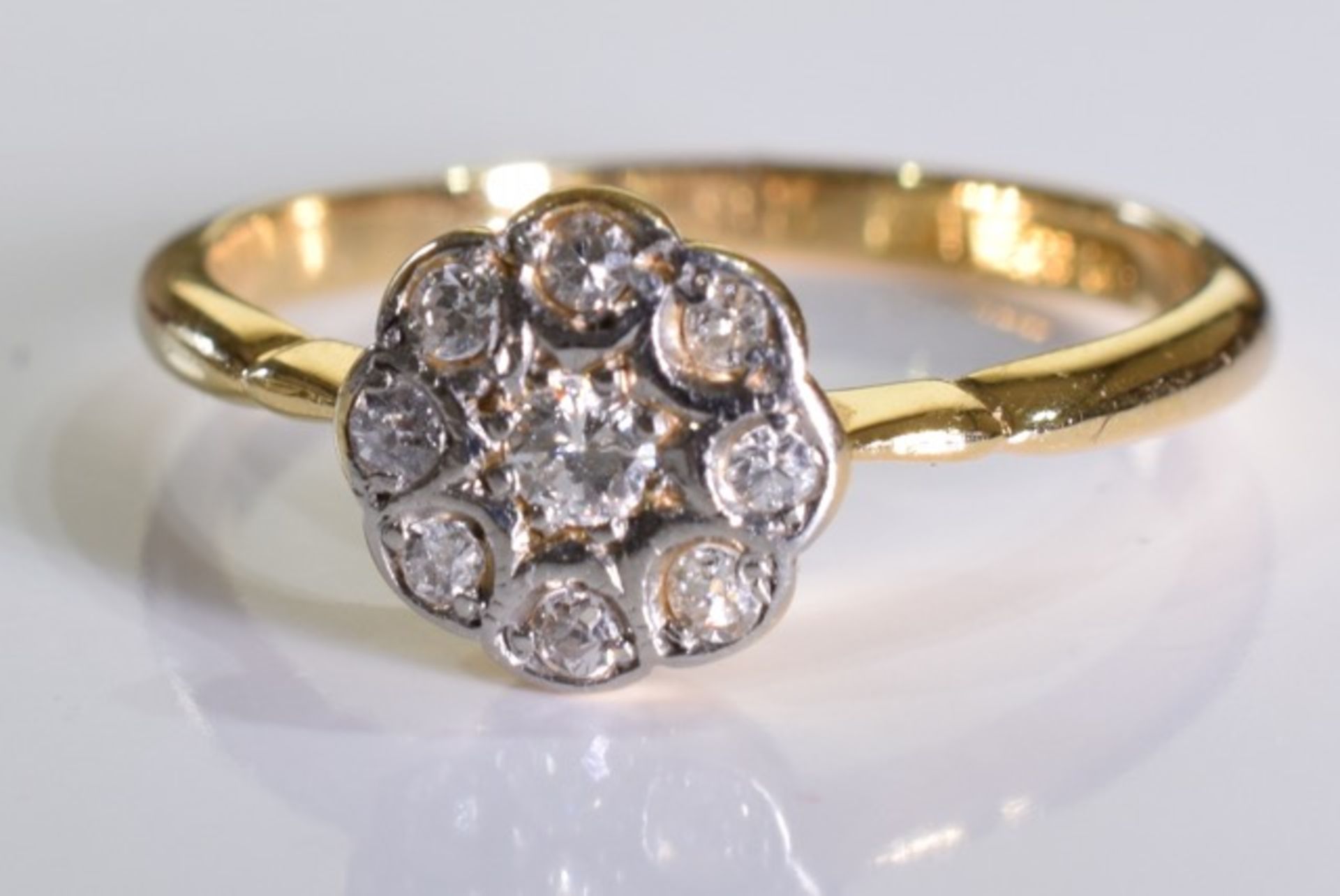 An 18ct gold diamond floral cluster ring. 2.3 grms - size M.