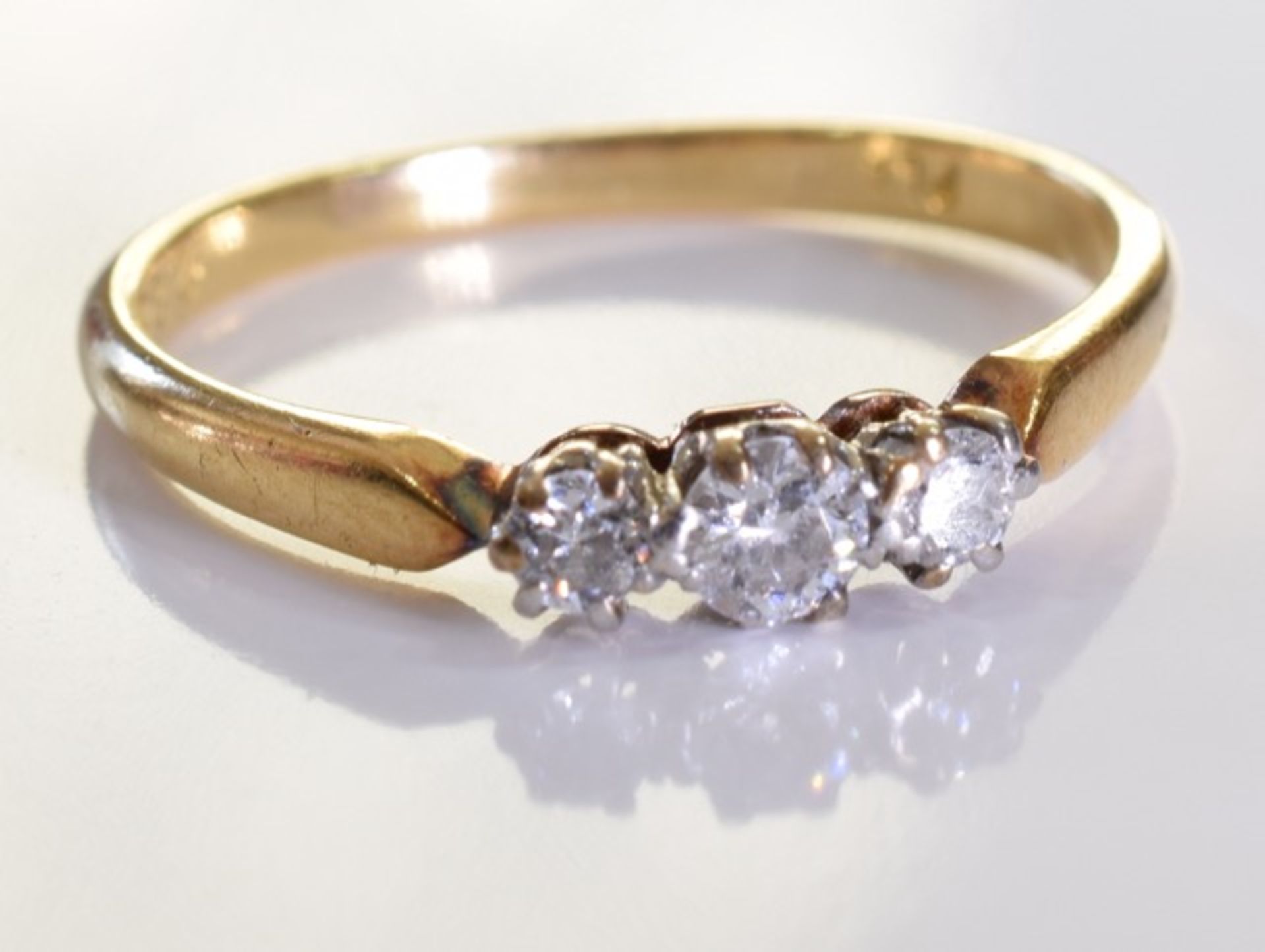 An 18ct Gold & Diamond Ring, Three graduated brilliant cut diamonds, set in 18ct gold. 2.4grms -