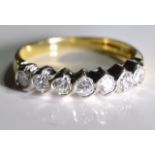 An 18ct gold diamond seven-stone ring. Each brilliant-cut diamond, within a curved spacer, to the